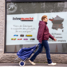 Imagen de archivo de una mujer caminando hacia un supermercado en París.