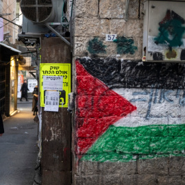 Un hombre judío ultraortodoxo pasa junto a una bandera palestina pintada en una pared del barrio de Jerusalén, una semana antes de que se celebren las elecciones al Knéset del 27 de octubre de 2026.