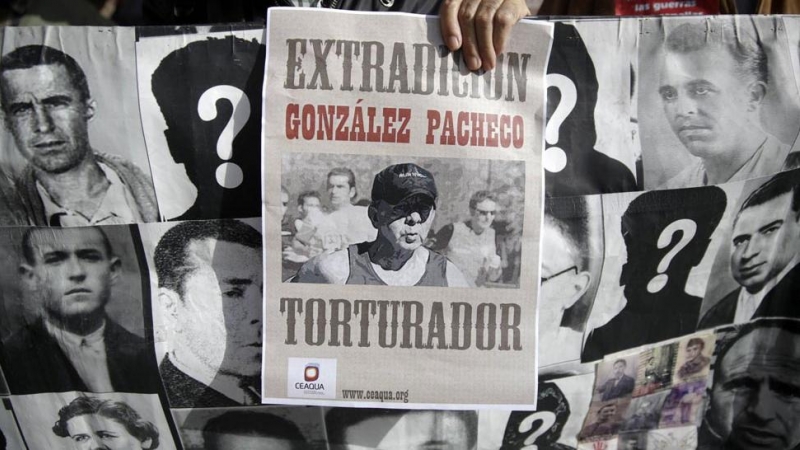 Familiares de víctimas de Franco protestan con una foto del ex inspector de policía Juan Antonio González Pacheco, conocido como 'Billy el niño', y una pancarta con fotografías de las víctimas.
