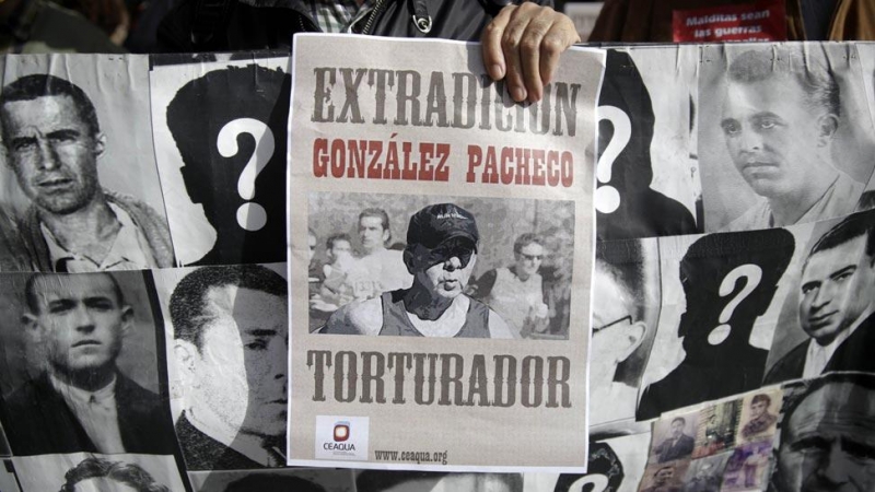 Familiares de víctimas de Franco protestan con una foto del ex inspector de policía Juan Antonio González Pacheco, conocido como 'Billy el niño', y una pancarta con fotografías de las víctimas.
