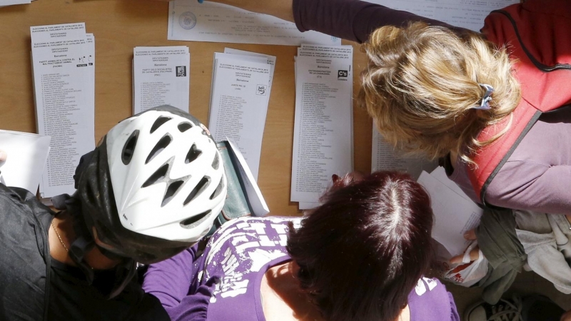 Varias personas escogen su papeleta para las elecciones al Parlamente de este 27-S en una mesa de un colegio electoral de Barcelona. REUTERS/Albert Gea