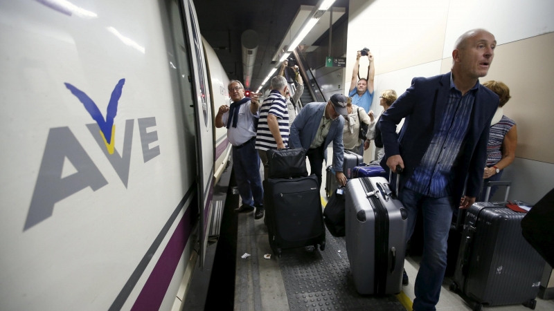 Pasajeros con sus maletas andando por un andén de la estación de Sans de Barcelona tras tener que bajarse de un tren AVE. /REUTERS