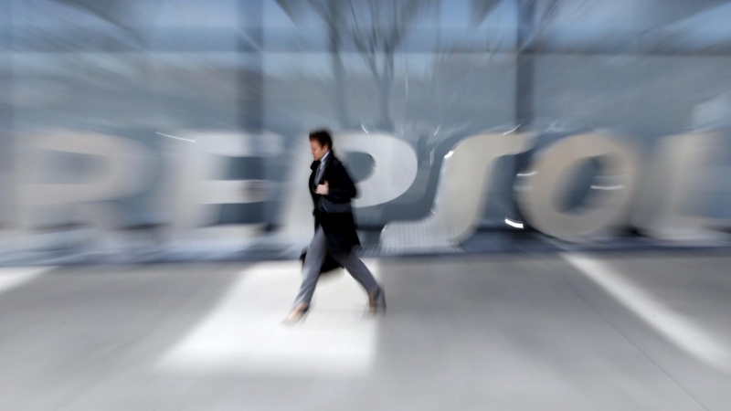 Un hombre pasa por delante del logo de Repsol en su sede de Madrid. REUTERS/Susana Vera