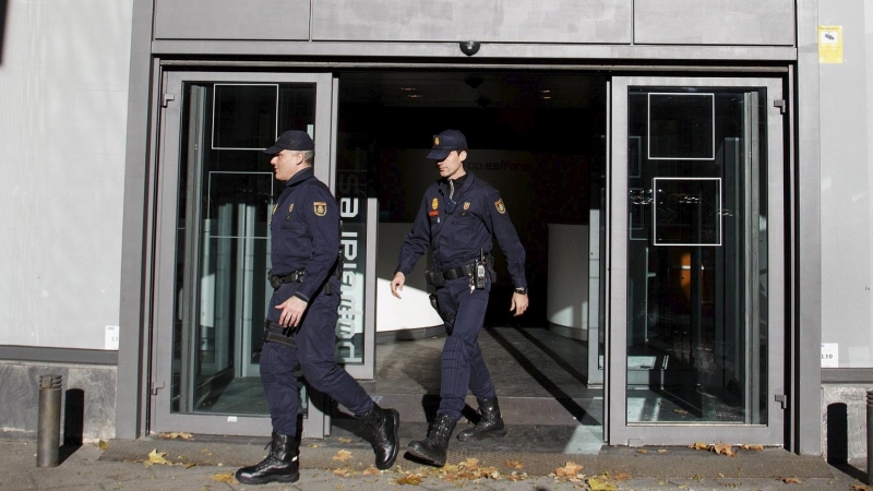 Dos agentes de Policía salen de la sede del PP en la madrileña calle de Génova, tras el registro realizado en diciembre de 2013 durante 14 horas en busca de documentación sobre el pago en B de las obras del edificio, en . REUTERS/Paul Hanna