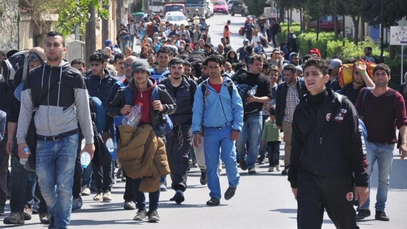 Solicitantes de asilo caminan por una calle de la isla griega de Quíos. / ORESTIS PANAGIOTOU (EFE)