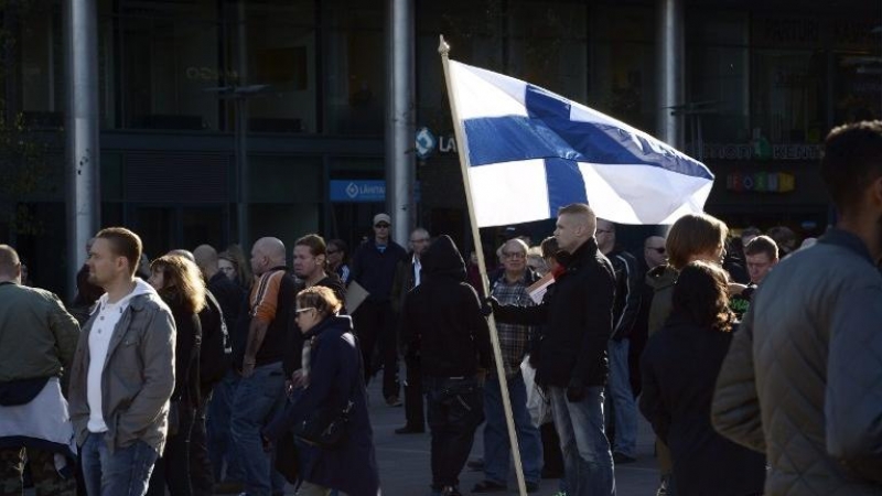 Un manifestante antiinmigración con una bandera de Finlandia durante una protesta en Helsinki. - AFP