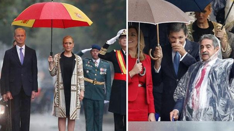 Cifuentes y Revilla se resguardan de la lluvia durante el desfile.- EFE