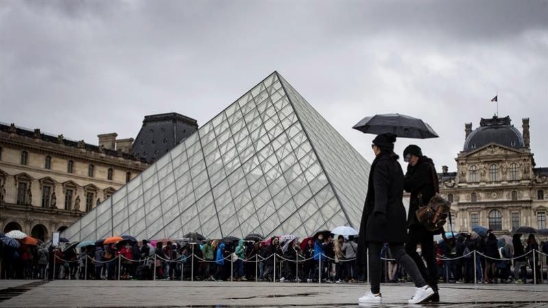 Turistas ante el museo del Louvre, en París. / IAN LANGSDON (EFE)