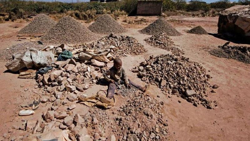 Un niño rompe rocas extraídas de una minería de cobalto en una mina de cobre y un pozo de cobalto en Lubumbashi el 23 de mayo de 2016. El precio del cobre ha caído fuertemente, afectando directamente a los trabajadores de la ciudad. JUNIOR KANNAH / AFP