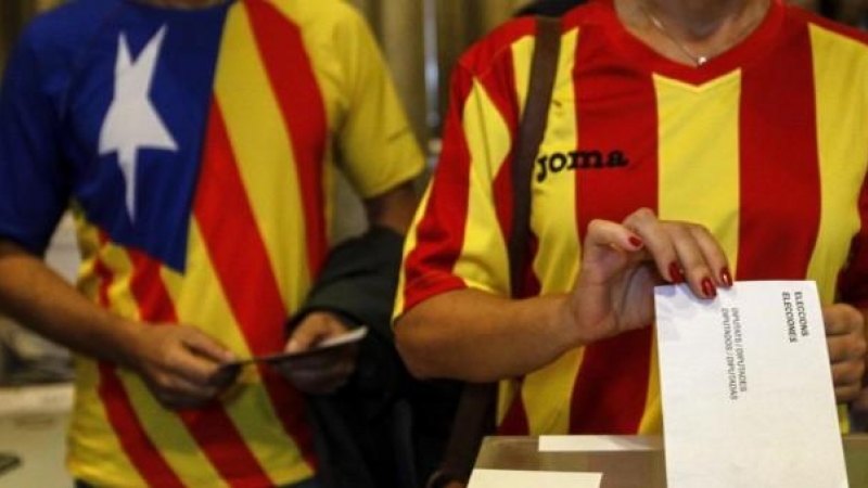Una ciudadana deposita su voto en una mesa de en un colegio electoral de Barcelona durante el referéndum que tuvo lugar el 9-N del año 2014.- EFE
