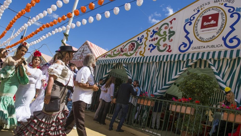 Unas personas llegan a la caseta que el Ayuntamiento sevillano ha dispuesto abierta para los turistas que visitan la Feria de Abril, ya que la mayoría son privadas. EFE/ Raúl Caro