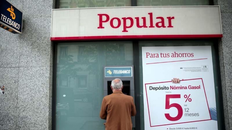 Un hombre retira dinero de un cajero de una sucursal del Banco Popular en Madrid. | EFE