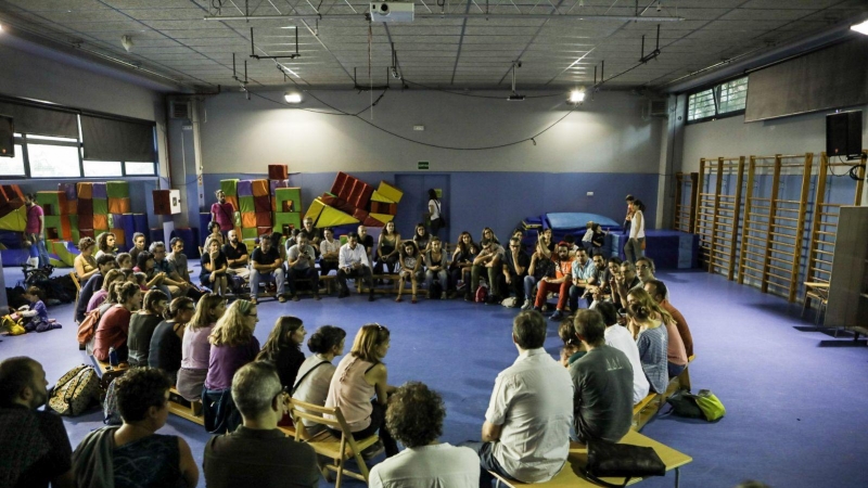 Famílies de l'escola i veïns del barri discuteixen en assemblea com mantenir oberta l'escola fins el matí de diumenge. XAVI HERRERO