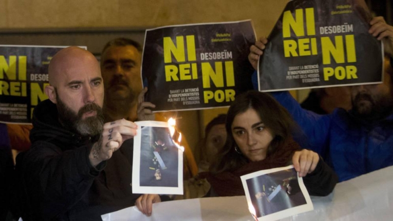 El concejal de la CUP en el Ayuntamiento de Barcelona Josep Garganté (i) quema una foto del Rey (Efe).