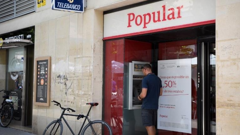 Un hombre saca dinero de un cajero automático del Banco Popular, en la localidad barcelonesa de Vilanova i la Geltru, en una foto del 7 de junio de 2017, el día que se anunció la resolución de la entidad. AFP/Lluis Gené