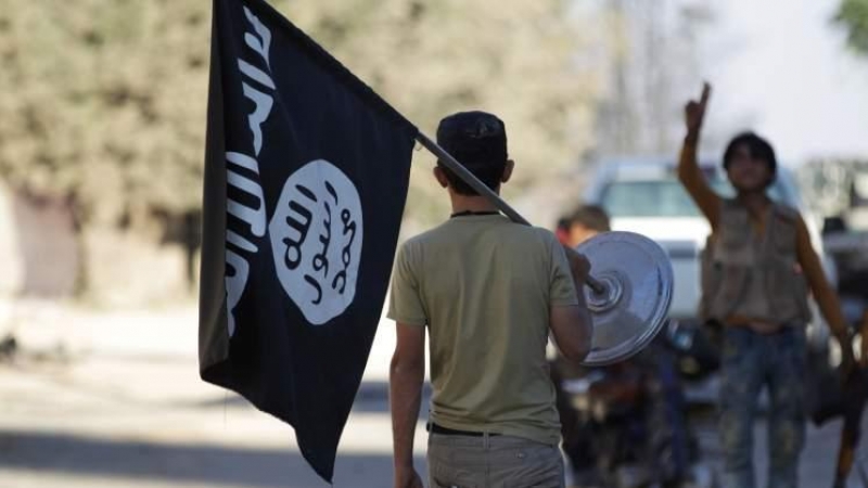 Un chico exhibe la bandera del Estado Islámico por la calle, en una foto de archivo. | EFE