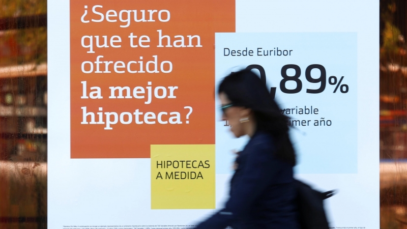 Una mujer pasa junto a una publicidad de hipotecas en una sucursal de Bankinter. REUTERS/Susana Vera