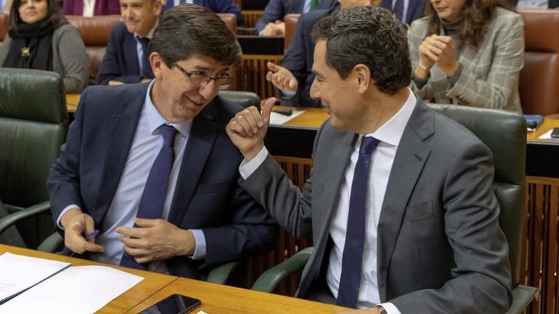 06/02/2019.- El presidente andaluz, Juanma Moreno, y el vicepresidente, Juan Marín (i), conversan en sus escaños durante el pleno del Parlamento de Andalucía esta tarde en Sevilla, que ha elegido, en la primera sesión plenaria de la XI Legislatura, a los