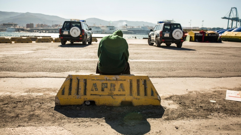 Un migrante descansa en el puerto de Algeciras, custodiado por la Guardia Civil tras ser rescatado por Salvamento Marítimo junto a potros migrantes a bordo de una patera.- JAIRO VARGAS