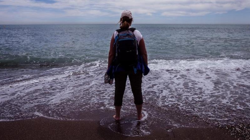 Una turista se refresca los pies en la playa de la Malagueta en Málaga. - EFE