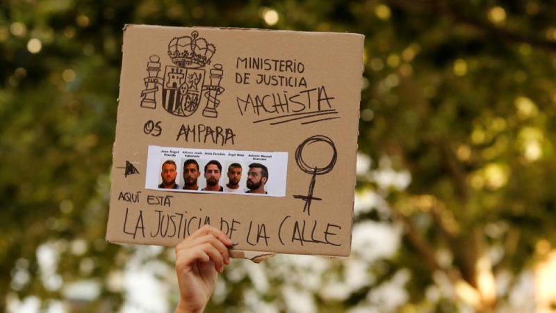 La imagen de los cinco miembros de la llamada Manada, en una pancarta sostenida por una manifestante en una protesta en Sevilla en junio de 2018. REUTERS/Marcelo del Pozo