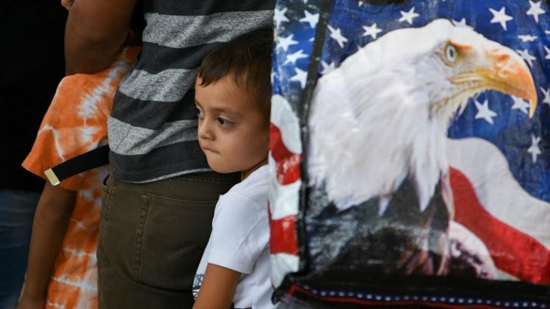 Un niño migrante de Guatemala de cinco años y su familia esperan con otros solicitantes de asilo, liberados tras ser detenidos en la frontera de EEUU con México.- REUTERS