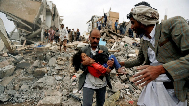 Un hombre lleva en brazos a una niña herida en un bombardeo de la coalición saudí contra Yemen en agosto de 2017. Khaled Abdullah / REUTERS