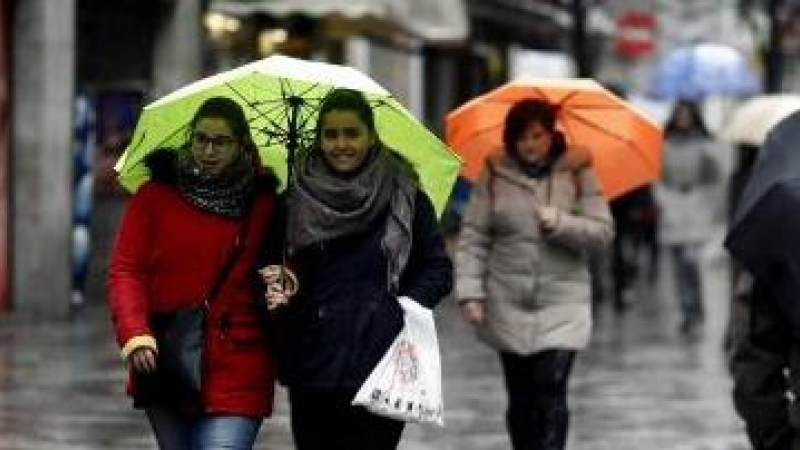 Imagen de archivo de ciudadanos paseando el frío y la lluvia. EUROPA PRESS/Óscar del Pozo