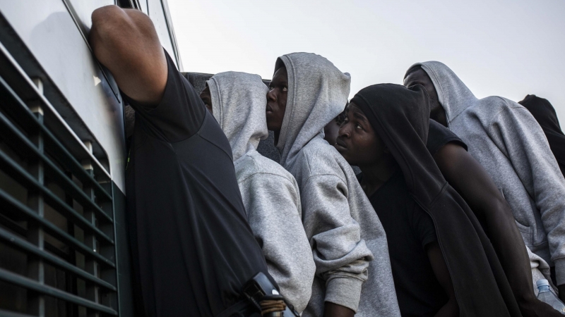 Varios migrantes suben a un autobús de la Guardia Civil para ser trasladados desde el puerto de Algeciras, en agosto de 2018.- JAIRO VARGAS (ARCHIVO)