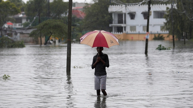 Un hombre sujeta un paraguas en una inundación en Colombo, Sri Lanka./ REUTERS