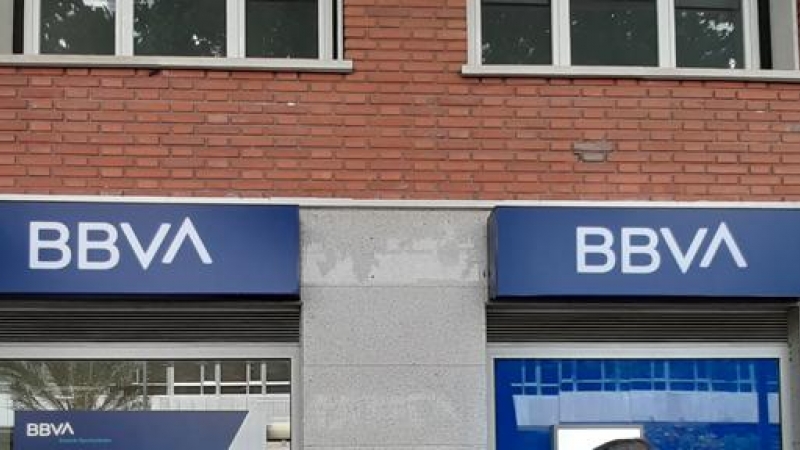 Una mujer pasa una oficina bancaria con el nuevo logo del BBVA en Madrid. E.P./Eduardo Parra