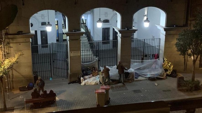 Imagen de varias personas durmiendo frente a las puertas de la sede del Samur Social. / EUROPA  PRESS