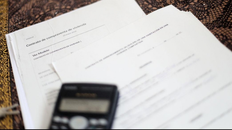 Una calculadora sobre un contrato de compraventa de vivienda y un contrato de arrendamiento (alquiler). E.P./Eduardo Parra