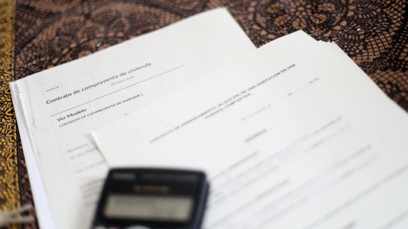 Una calculadora sobre un contrato de compraventa de vivienda y un contrato de arrendamiento (alquiler). E.P./Eduardo Parra