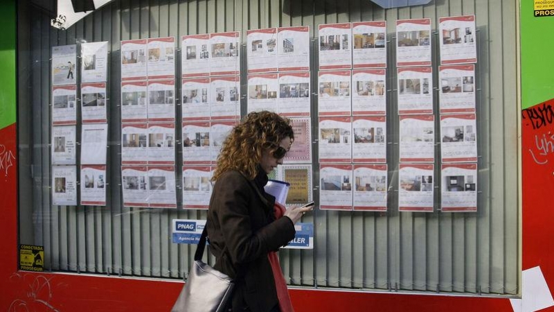Una joven pasa por delante de una inmobiliaria con anuncios de casas en alquiler o en venta en el centro de Madrid. REUTERS/Andrea Comas