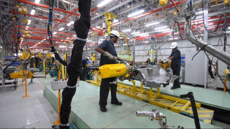 Imagen de archivo de dos trabajadores en el interior de una fábrica / EFE