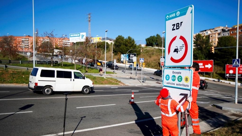 Técnicos del Ayuntamiento de Barcelona colocan la señal de la Zona de Bajas Emisiones./ Alejandro García (EFE)
