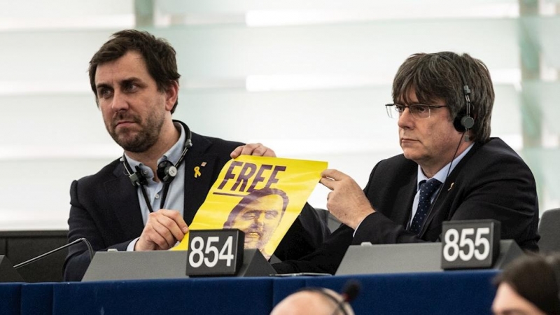 Carles Puigdemont y Toni Comín muestran un cartel que reclama la libertad de Oriol Junqueras en el Parlamento Europeo./ EFE/EPA/PATRICK SEEGER