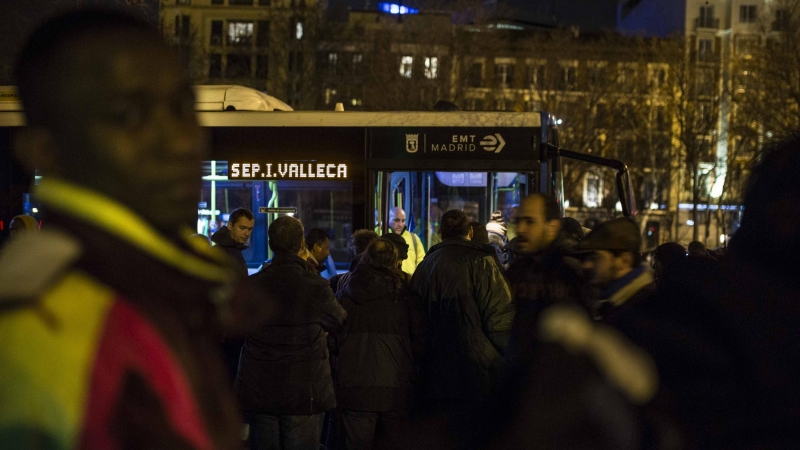 Personas sin hogar y solicitantes de asilo esperan al autobús que les llevará al albergue especial de la campaña de frío del Ayuntamiento de Madrid.- JAIRO VARGAS