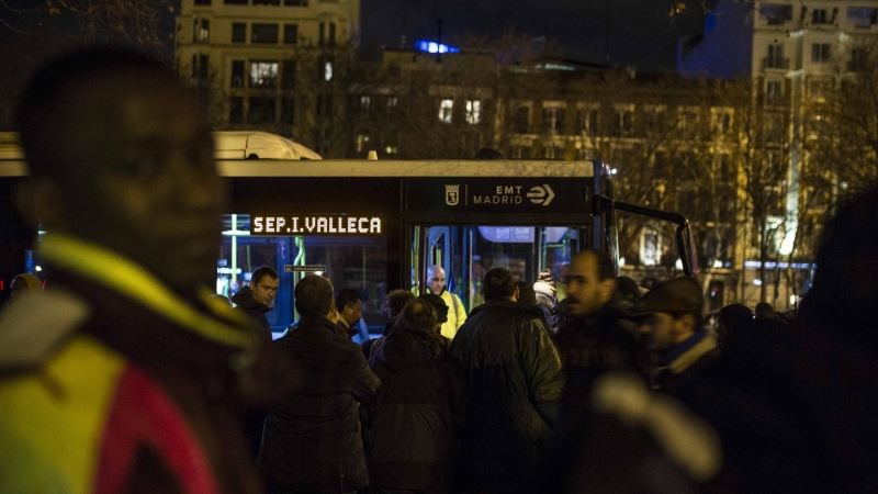 Personas sin hogar y solicitantes de asilo esperan al autobús que les llevará al albergue especial de la campaña de frío del Ayuntamiento de Madrid.- JAIRO VARGAS