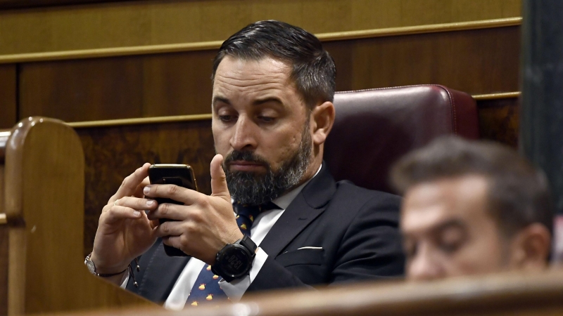 El líder de Vox, Santiago Abascal, utilizando su móvil en el Congreso. / Archivo