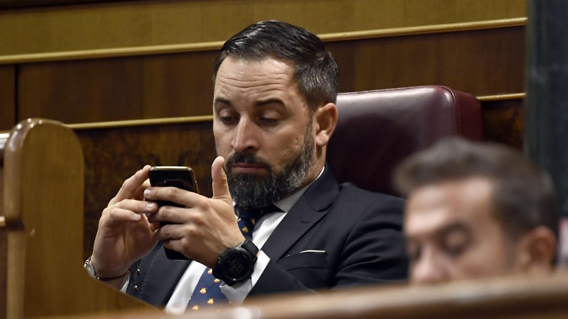 El líder de Vox, Santiago Abascal, utilizando su móvil en el Congreso. / Archivo