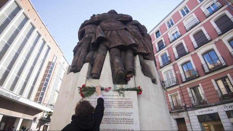 Una mujer coloca un ramo de flores en el monumento al crimen de Atocha / EFE (INMA FLORES)