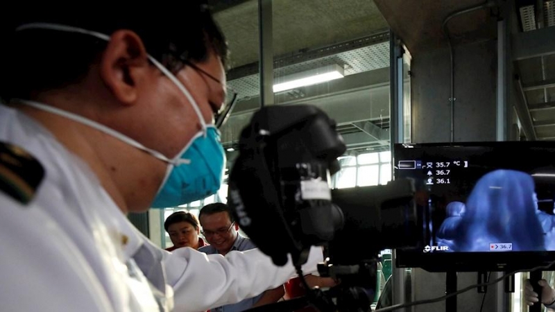 Funcionarios sanitarios instalan un escáner termal para monitorizar la temperatura de los pasajeros procedentes de vuelos internacionales, este viernes, en el aeropuerto de Suvarnabhumi, en la provincia de Samut Prakan (Tailandia)