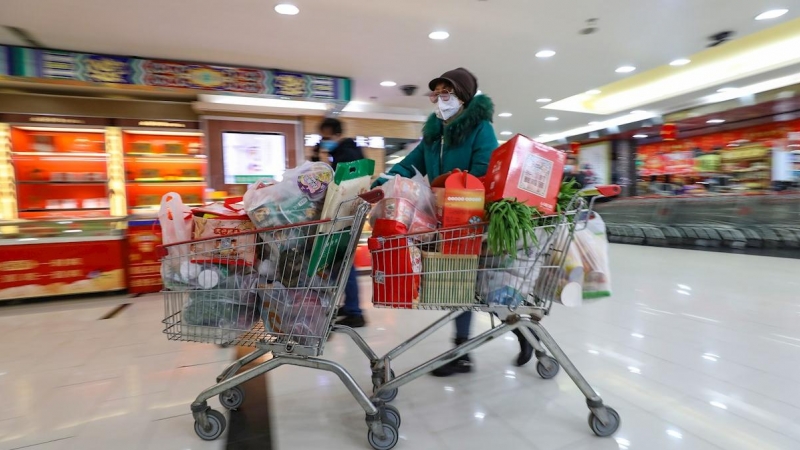 Una mujer con máscara compra en un supermercado en Wuhan. EFE