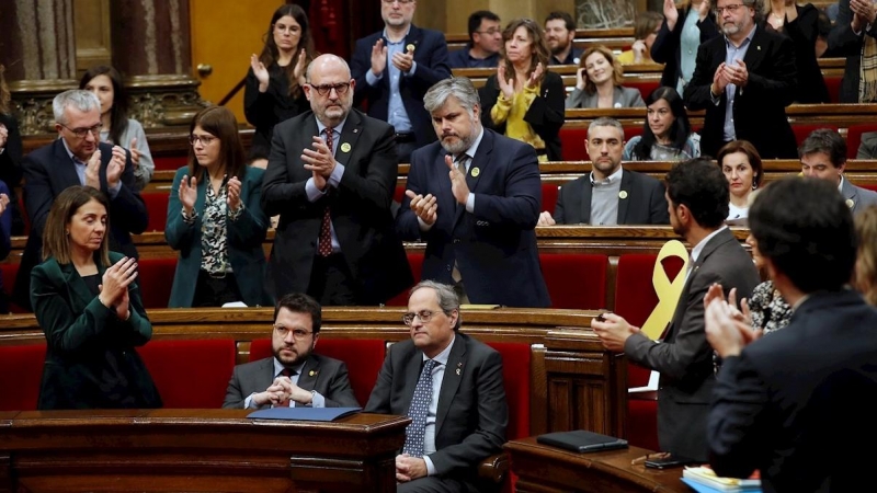 Els diputats i membres del Govern de JxCat aplaudeixen Torra mentre que els d'ERC s'ho miren. EFE / TONI ALBIR