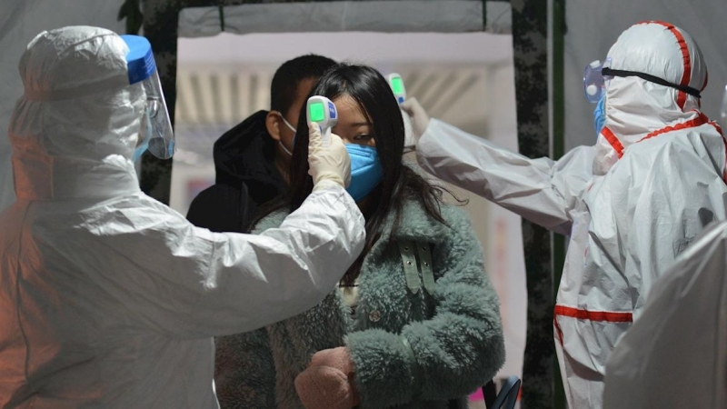 29/01/2020.- Trabajadores de una estación de ferrocarril toman la temperatura a los pasajeros en Fuyang (China). / EFE