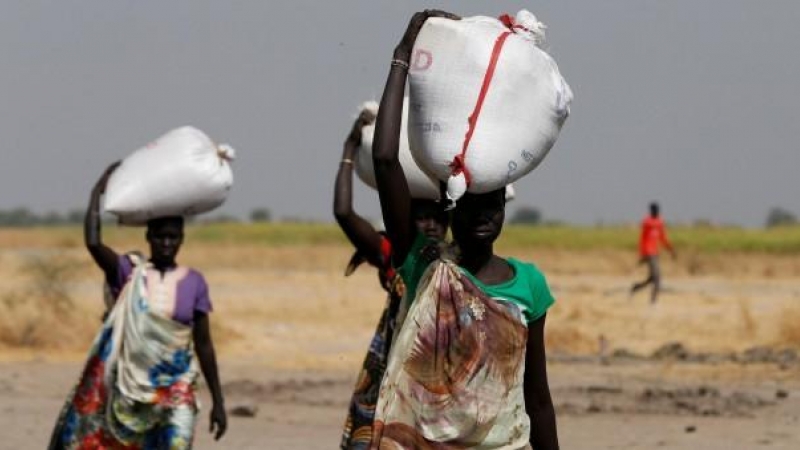 Varias mujeres llevan sacos de alimentos en el pueblo Nimini, en el estado de Unity, al norte de Sudán del Sur.- REUTERS / Siegfried Modola