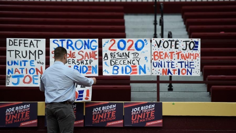 04/02/2020.-  Un hombre coloca carteles en un instituto de Iowa durante las primarias. / EFE - CRAIG LASSIG