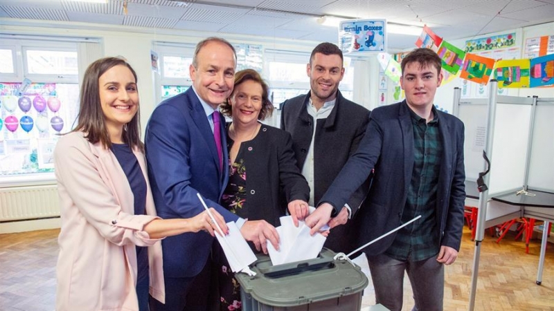 08/02/2020.- El líder del opositor Fianna Fail, Micheal Martin (2-izq), su esposa Mary O'Shea (c) y sus hijos Aoibhe (izq), Micheal (2-dcha) y Cillian (dcha) depositan sus votos en un colegio electoral en Cork (Irlanda), este sábado, durante la celebració